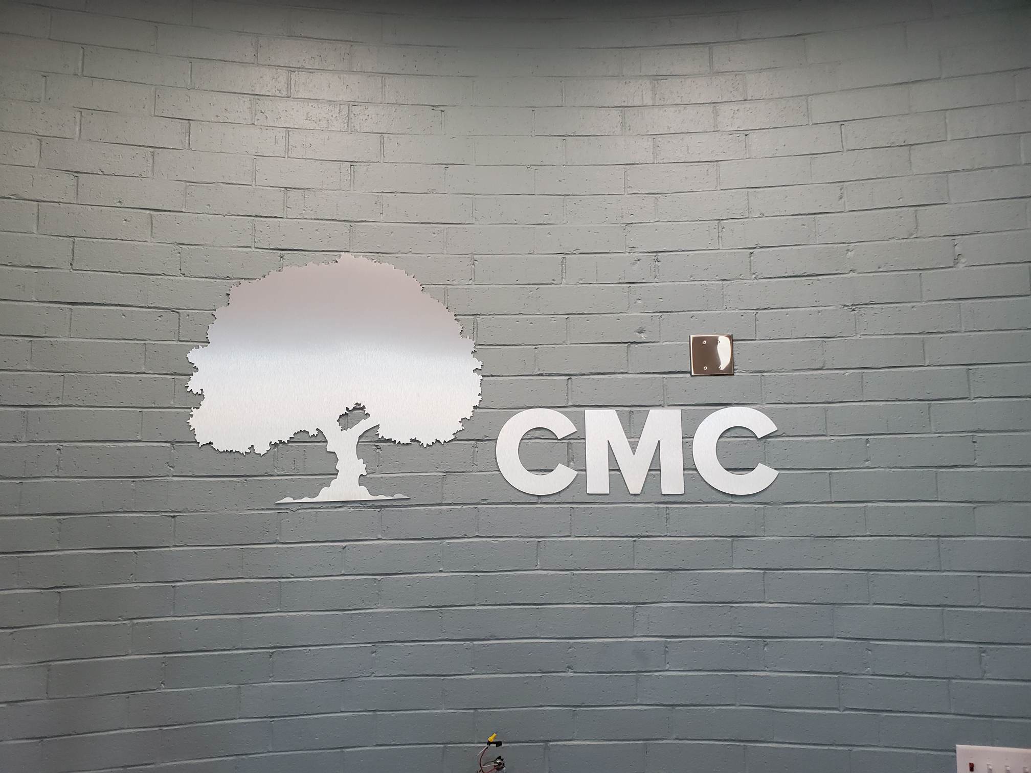 Logo with tree on brick wall